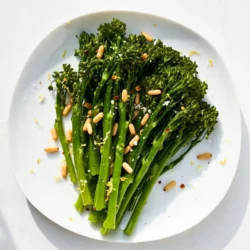 - 1 bunch of broccolini, trimmed - 3 tablespoons olive oil - 4 cloves garlic, minced - Zest of 1 lemon - Juice of 1 lemon - 1/4 teaspoon red pepper flakes (optional for spice) - Salt and pepper to taste - 1/4 cup pine nuts, toasted - 2 tablespoons grated parmesan cheese (optional) To make this tasty dish, you need fresh broccolini. Look for bright green stalks. Trim the ends to remove any tough parts. Garlic adds great flavor. Use fresh cloves for the best taste. Lemons bring a bright, zesty note. The zest gives a punch, while the juice adds a nice tang. Red pepper flakes add a spicy kick. You can leave them out if you want a milder dish. Don’t forget salt and pepper. They enhance all the flavors. Pine nuts add a crunchy texture. Toast them for a nutty flavor. Parmesan cheese is optional, but it adds richness. Gather all these ingredients before you start cooking. Having everything ready makes the process smooth and easy. Enjoy the burst of flavors in this simple yet delightful recipe! {{ingredient_image_1}} - First, wash the broccolini well under cold water. - Trim the thicker ends to ensure even cooking. - Heat 2 tablespoons of olive oil in a large skillet over medium heat. - Add minced garlic and sauté for 30 seconds until it smells great. - Quickly toss in the broccolini and mix it in the garlic oil. - Cook for 2-3 minutes until the broccolini turns bright green and is slightly tender. - If you like spice, add red pepper flakes, lemon zest, and lemon juice. - Season with salt and pepper to taste. - Cook for an extra 2-3 minutes until the broccolini is tender yet crisp. - In a small pan, toast the pine nuts over medium heat. - Stir them often until they are golden brown, about 3-4 minutes. To get the best texture from broccolini, timing is key. Cook it for about 5-6 minutes total. Start with 2-3 minutes in the skillet for a tender crunch. The bright green color shows it's ready. If you overcook it, the broccolini will lose its crispness. Keep an eye on it to ensure you get that perfect bite. You can add more flavor with fun seasonings. Try a squeeze of lime for a twist. Chilli flakes give heat, while sesame seeds add crunch. You can also swap pine nuts for almonds or walnuts. If you want to change it up, add a bit of soy sauce for umami. Fresh herbs like basil or parsley will brighten the dish too. Lemon garlic broccolini pairs well with many meals. Serve it alongside grilled chicken or fish for a bright touch. It also shines next to pasta dishes. For a nice look, place it on a large plate and sprinkle the pine nuts on top. You can drizzle a little extra olive oil for a finishing touch. Enjoy your colorful and tasty meal! Pro Tips Freshness Matters: Use fresh broccolini for the best flavor and texture. Look for vibrant green stalks and avoid any yellowing leaves. Perfectly Toasted Nuts: Keep an eye on the pine nuts while toasting; they can burn quickly. Stir frequently and remove them from the heat as soon as they turn golden brown. Garlic Sautéing: Sauté the garlic just until fragrant to avoid bitterness. If it starts to brown too much, lower the heat immediately. Serve Immediately: This dish is best enjoyed fresh. Serve right after cooking to retain the broccolini's crispness and vibrant color. {{image_2}} You can change nuts or cheese to fit your taste. If you don’t have pine nuts, try walnuts or almonds. They add a nice crunch too. For cheese, use feta or goat cheese if you want a different flavor. Both work well with lemon and garlic. You can even skip cheese if you prefer a lighter dish. Broccolini is versatile and can be cooked in various ways. If you want a smoky flavor, grill the broccolini instead of sautéing it. Just toss it on a hot grill for about 5-7 minutes, turning occasionally. You can also steam it for a softer texture. Steaming takes about 4-5 minutes. Just make sure it stays bright green. You can easily adjust the spice level in this dish. If you like it hot, add more red pepper flakes. For a milder taste, skip them altogether. You can also add more lemon juice to boost the citrus flavor. A splash of balsamic vinegar can add depth too. Just taste as you go to find what you like best. To store leftover broccolini, let it cool first. Place it in an airtight container. Keep it in the fridge. It will stay fresh for up to three days. If you want to keep it longer, avoid adding any toppings. This keeps it crisp and flavorful. The best way to reheat broccolini is in a skillet. Heat a little olive oil over medium heat. Add the broccolini and stir for a few minutes. This method keeps the flavor and texture. You can also use a microwave. However, it may lose some crunchiness. To use the microwave, cover it loosely and heat for about 30 seconds. If you want to freeze broccolini, blanch it first. Boil it for two minutes, then plunge it into ice water. This stops the cooking. Drain and dry before placing it in a freezer bag. Broccolini can last for up to three months in the freezer. To thaw, place it in the fridge overnight or microwave on low. This method helps keep the flavor and color bright. Broccolini is a green vegetable. It looks like a mix of broccoli and Chinese broccoli. It has long, thin stems and small florets. Broccolini has a sweet and mild taste. It cooks faster than regular broccoli. You can eat it raw or cooked. Yes, you can use frozen broccolini. Just make sure you don't thaw it first. Cook it straight from the freezer. This helps keep its crunch. You may need to add a minute or two to the cooking time. Check for tenderness, but don’t overcook it. To make this dish vegan, skip the cheese. You can use nutritional yeast for a cheesy flavor. Instead of olive oil, use avocado oil or any other plant-based oil. This keeps the dish tasty while being vegan-friendly. This blog detailed how to prepare a tasty broccolini dish. We covered the key ingredients, step-by-step cooking, and tips for the best texture and flavor. I offered variations to keep it fun and fresh. Plus, I included storage tips to enjoy leftovers later. Broccolini is easy to make and very versatile. Experiment with different nuts and spices. With these ideas, you'll create a dish that everyone will love. Remember, cooking is all about trying new things!