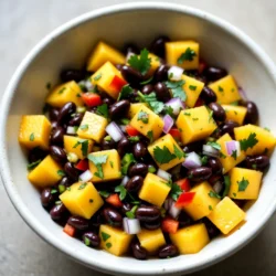- Ripe mango - Black beans - Red bell pepper - Red onion - Jalapeño - Fresh cilantro - Lime juice - Olive oil - Salt and pepper Gathering fresh ingredients is key for the best flavor. Start with a ripe mango. Look for one that feels soft yet firm. Ripe mangoes are sweet and juicy, which adds a great taste. Next, grab a can of black beans. Rinse and drain them well. Black beans bring a nice texture and add protein. Choose a red bell pepper for its sweetness. Chop it finely, so it blends well with other ingredients. A small red onion adds sharpness and color. Finely chop it to mix easily into the salsa. For some heat, add a jalapeño. Make sure to deseed and mince it. Adjust the amount to control spice level based on your taste. Fresh cilantro is a must. Chop about 1/4 cup for its bright flavor. Lime juice adds zest and tang. Use the juice of two limes for a fresh kick. Drizzle in two tablespoons of olive oil. It adds richness and helps blend the flavors. Finally, season with salt and pepper to taste. These simple seasonings enhance all the fresh ingredients. With these ingredients, you will create a fresh and flavorful salsa that is sure to impress. {{ingredient_image_1}} To make Mango Black Bean Salsa, start by mixing the ingredients. In a large bowl, combine the diced mango, black beans, finely chopped red bell pepper, and red onion. Don’t forget to add the minced jalapeño for some heat. This mix of ingredients gives you a colorful base. Next, it's time to add the lime juice and olive oil. Squeeze the juice from two limes directly over the mix. Then, drizzle in two tablespoons of olive oil. This will add shine and flavor. Now, season to taste. Sprinkle salt and pepper over the mixture. You can adjust the lime or olive oil to fit your taste. Make sure everything is evenly coated. When mixing, be sure to toss gently. This helps keep the mango pieces intact. A gentle toss also blends the flavors without mashing the ingredients. Letting the salsa sit for about 15 minutes is key. This allows the flavors to meld together. The wait is worth it! You will taste a burst of freshness in every bite. Choosing the right mango Pick a mango that feels soft but not mushy. A ripe mango has a sweet smell. It should have a golden color with some red. If you can't find ripe mangoes, let them sit at room temperature for a few days. This will help them ripen. Adjusting spice levels If you like heat, leave some seeds in the jalapeño. For less heat, use only half of the jalapeño. You can also replace it with a sweet pepper. This way, you keep the flavor without the spice. Ideal garnishes Garnish your salsa with whole cilantro leaves. This adds color and freshness. You can also add slices of lime on the side. It looks great and lets people add more lime if they want. Pairing with tortilla chips Serve the salsa with crispy tortilla chips. The crunch pairs well with the soft mango and beans. You can also use veggie sticks like carrots or cucumbers. This makes a fun, fresh snack or appetizer. Pro Tips Choose the Right Mango: Select a ripe mango that gives slightly when pressed. This ensures maximum sweetness and juiciness. Fresh Ingredients Matter: Use fresh lime juice and high-quality olive oil for the best flavor. Avoid bottled lime juice if possible. Adjust Heat Level: For a milder salsa, remove all seeds from the jalapeño. For more heat, keep some seeds or add a pinch of cayenne pepper. Chill Before Serving: Allow the salsa to chill in the refrigerator for 30 minutes before serving for enhanced flavor melding. {{image_2}} You can easily change the fruit in this salsa. Pineapple adds a sweet twist. Avocado gives it a creamy texture. Both fruits brighten the dish and add flavor. Feel free to try any fruit you love! You can also switch out the black beans. Kidney beans offer a different taste and color. Chickpeas add a nutty flavor and extra protein. These swaps keep the recipe fresh and exciting. Adding spices can bring new life to your salsa. Cumin adds warmth and depth. A pinch of garlic powder can enhance the taste too. Both spices work well with the other flavors. You can use different herbs for a twist. Mint adds a refreshing taste. Parsley gives a clean flavor that balances the sweetness of mango. Try mixing and matching to find your favorite combination! To keep your mango black bean salsa fresh, store it in an airtight container. This helps maintain its taste and crunch. Place the container in the fridge right after serving. The salsa stays fresh for up to three days. After that, the flavors may fade, and the veggies can get soggy. If you want to store the salsa for a longer time, freezing is a great option. You can freeze it in a freezer-safe bag or container. Make sure to remove as much air as possible before sealing. This helps prevent freezer burn. The salsa can stay good in the freezer for up to three months. For thawing, take the salsa out of the freezer and place it in the fridge overnight. This keeps the texture nice. You can also run the sealed bag under cold water for quicker thawing. Avoid using a microwave, as it can make the salsa mushy. To pick a ripe mango, look for a mango that is slightly soft. It should have a sweet smell near the stem. The color can vary, but it should have some yellow or red. Avoid hard or very green mangoes. Yes, you can make this salsa ahead of time. Just mix all the ingredients and store it in the fridge. It is best if you eat it within 24 hours. This salsa tastes great after the flavors blend. This salsa has a mild heat from the jalapeño. If you want less spice, remove the seeds and membranes. You can also use less jalapeño for a milder taste or skip it altogether. Mango Black Bean Salsa is great with tortilla chips. You can also serve it with grilled chicken or fish. It makes a colorful topping for tacos or salads, adding a fresh touch to any dish. This blog covered how to make a fresh and tasty Mango Black Bean Salsa. You learned about the key ingredients, like ripe mango and black beans. I shared easy steps for mixing and tips for perfect flavor. You can customize your salsa with various fruits and spices. Lastly, I discussed how to store your salsa for freshness. Enjoy making this vibrant dish. It’s perfect for sharing at any gathering!